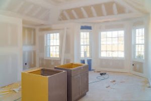 Finishing putty in the room drywalls with plasterboards at a residential building under construction