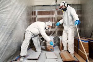 Male Workers Painting Wood With Spray Paint In Workshop